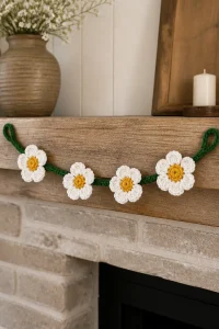 Crochet Dogwood Flower Mantel Garland beautifully displayed over a cozy fireplace.